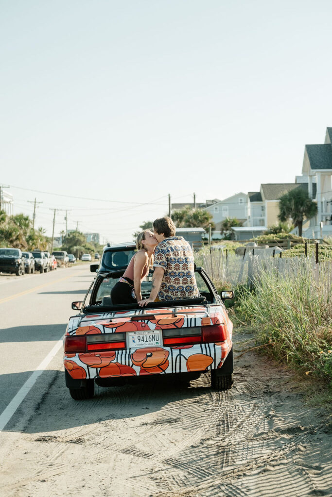 folly beach engagement with poppy car drive up beach engagement inspo of couple kissing