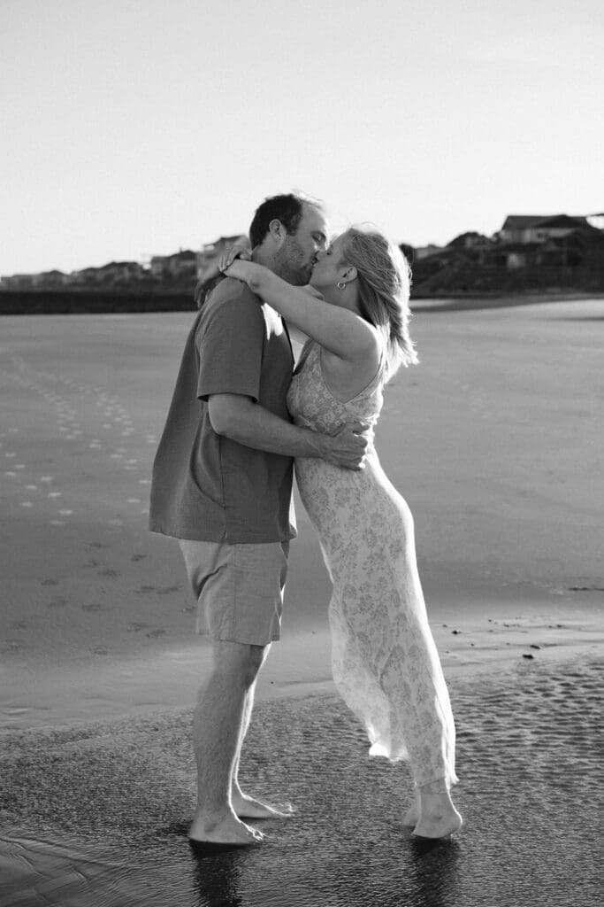 couple walking on beach documentary style photography wedding and engagement
black and white photo of couple kissing on beach