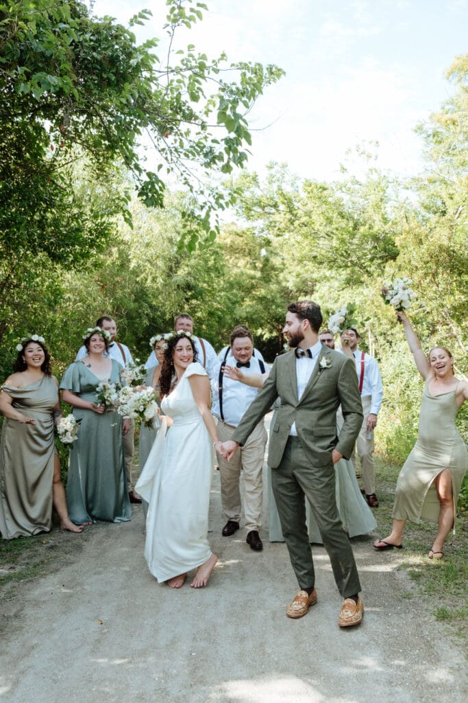 wedding party picture with bride and groom walking on beach sullivans island sc