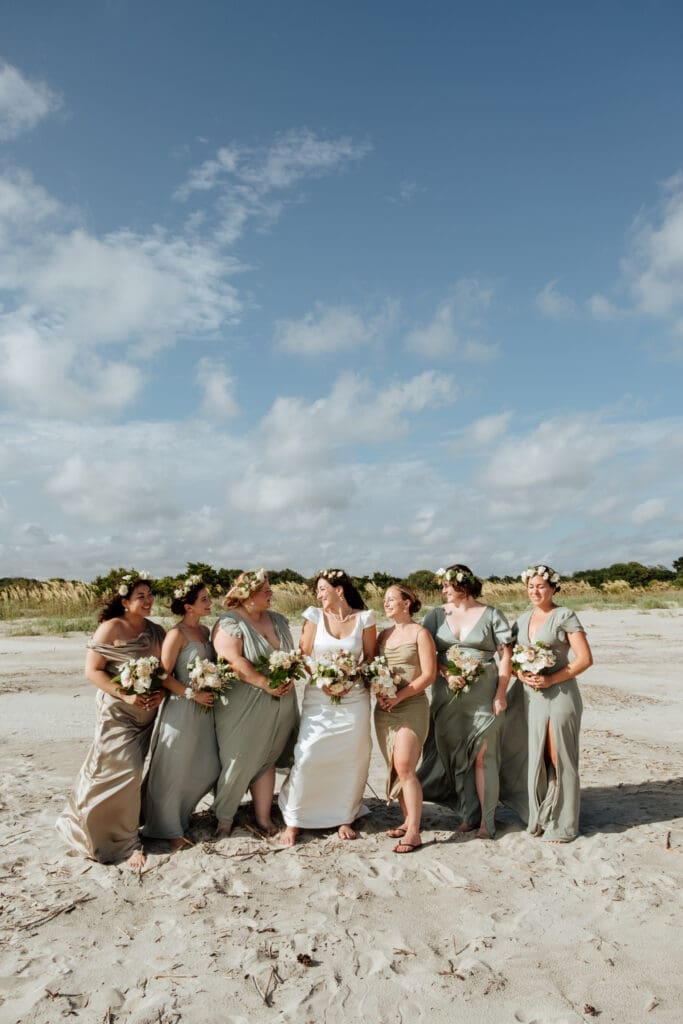 bride with bridesmaids group photo wedding day on beach