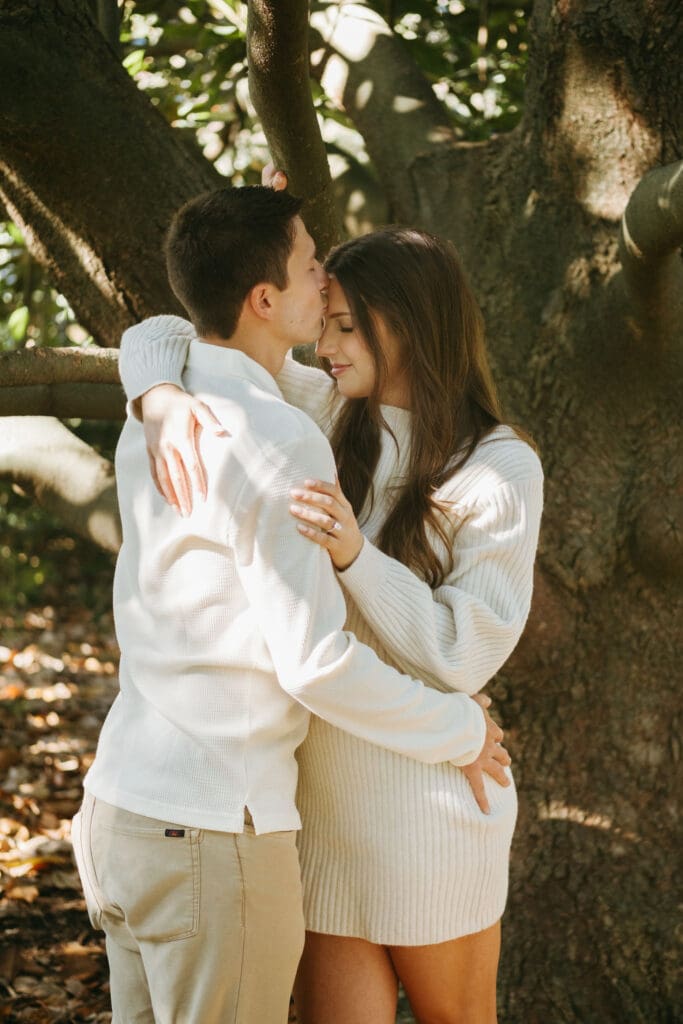 couple under tree kissing forhead hampton park engagement photoshoot