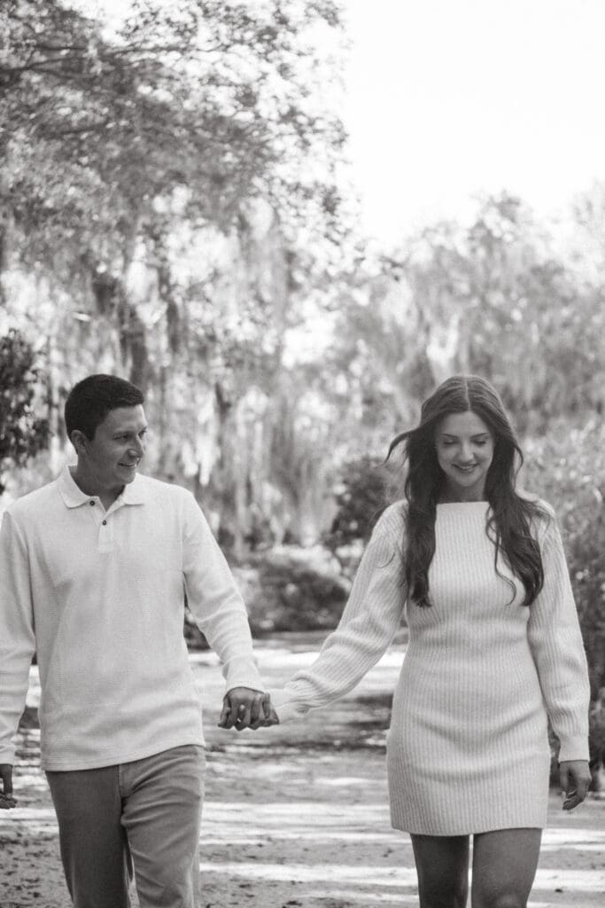 black and white picture of couple walking at park in nature candid hampton park engagement photoshoot