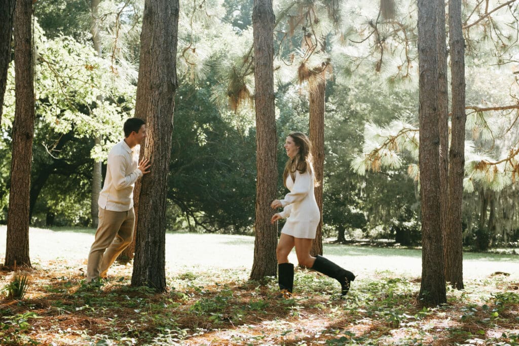 engagement shoot documentary style candid of couple running outside under tree hampton park engagement photoshoot