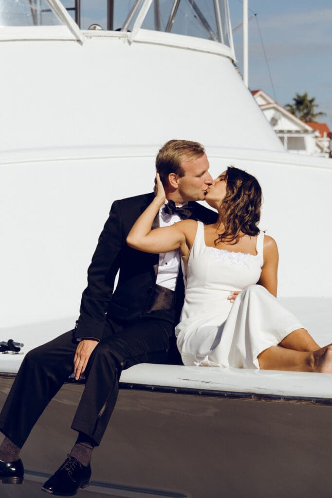 bride and groom editorial style portraits on boat shem creek charleston south carolina couple kissing