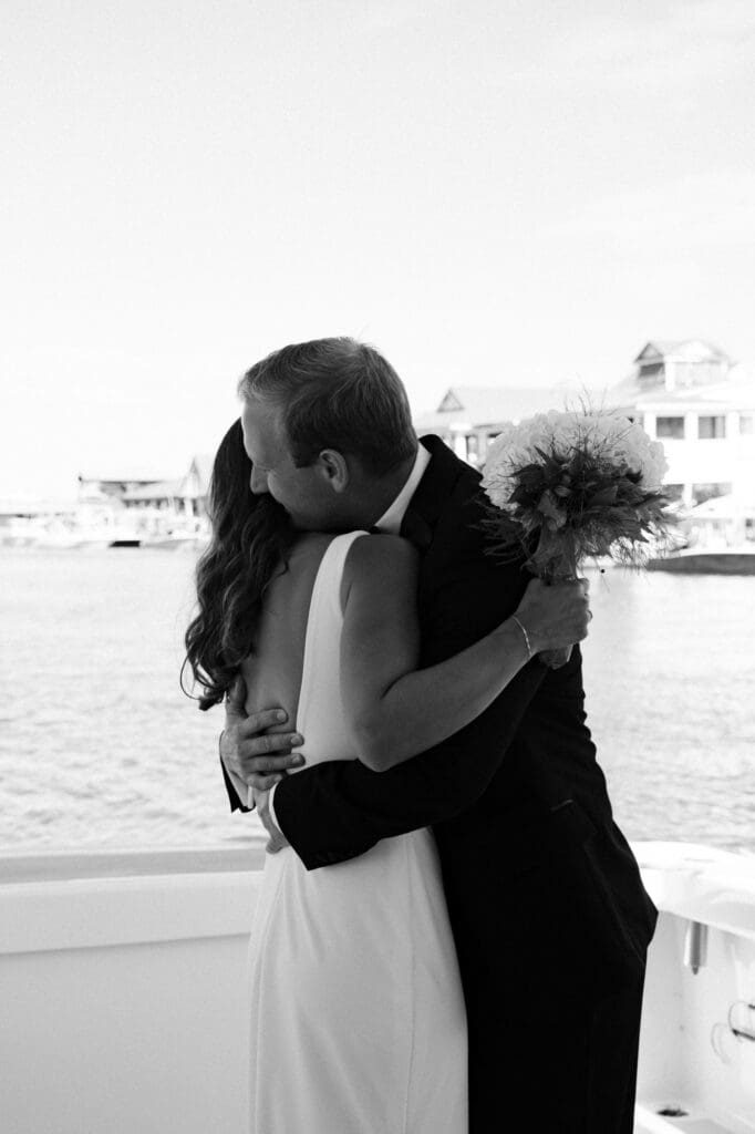 charleston documentary wedding photographer candid couple on boat black and white photo of couple hugging for first look