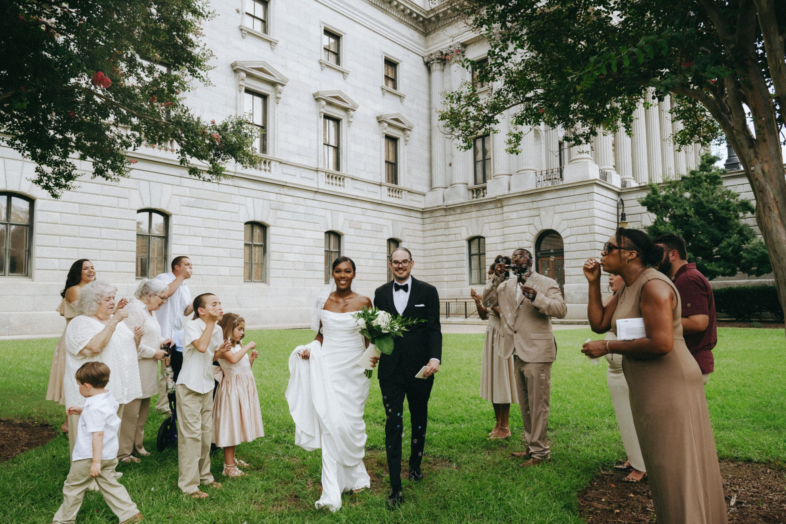 couple getting married outside of the courthouse in columbia sc with family on lawn