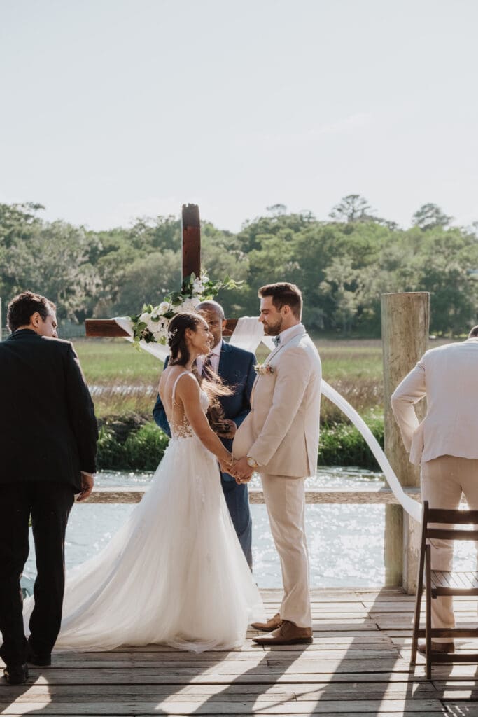 candid shot of bride and groom during ceremony at cotton dock at boone hall plantation