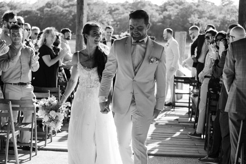bride and groom walking down the isle after getting married at cotton dock boone hall plantation black and white