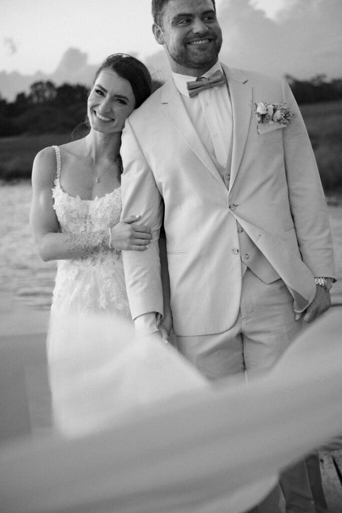 black and white photo of bride and groom portraits at cotton dock at boone hall at sunset