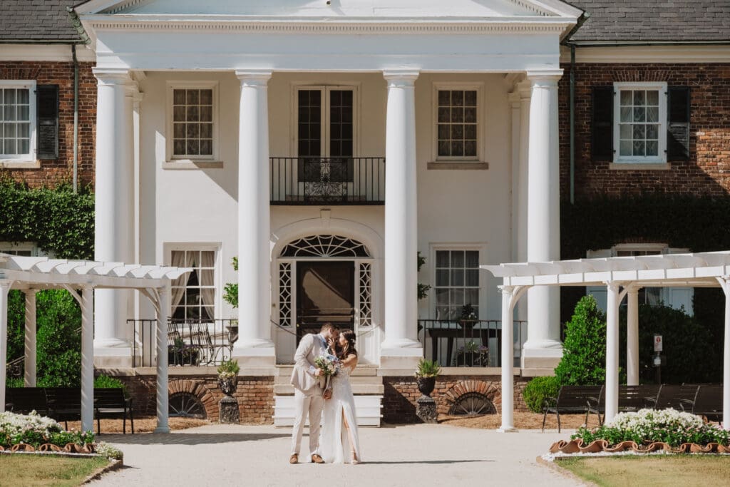 bride and groom portrait with flowers at boone hall plantation infront of house