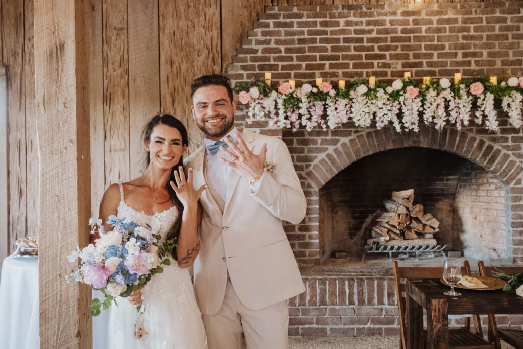 Bride and Groom posing with rings at Cotton Dock at reception