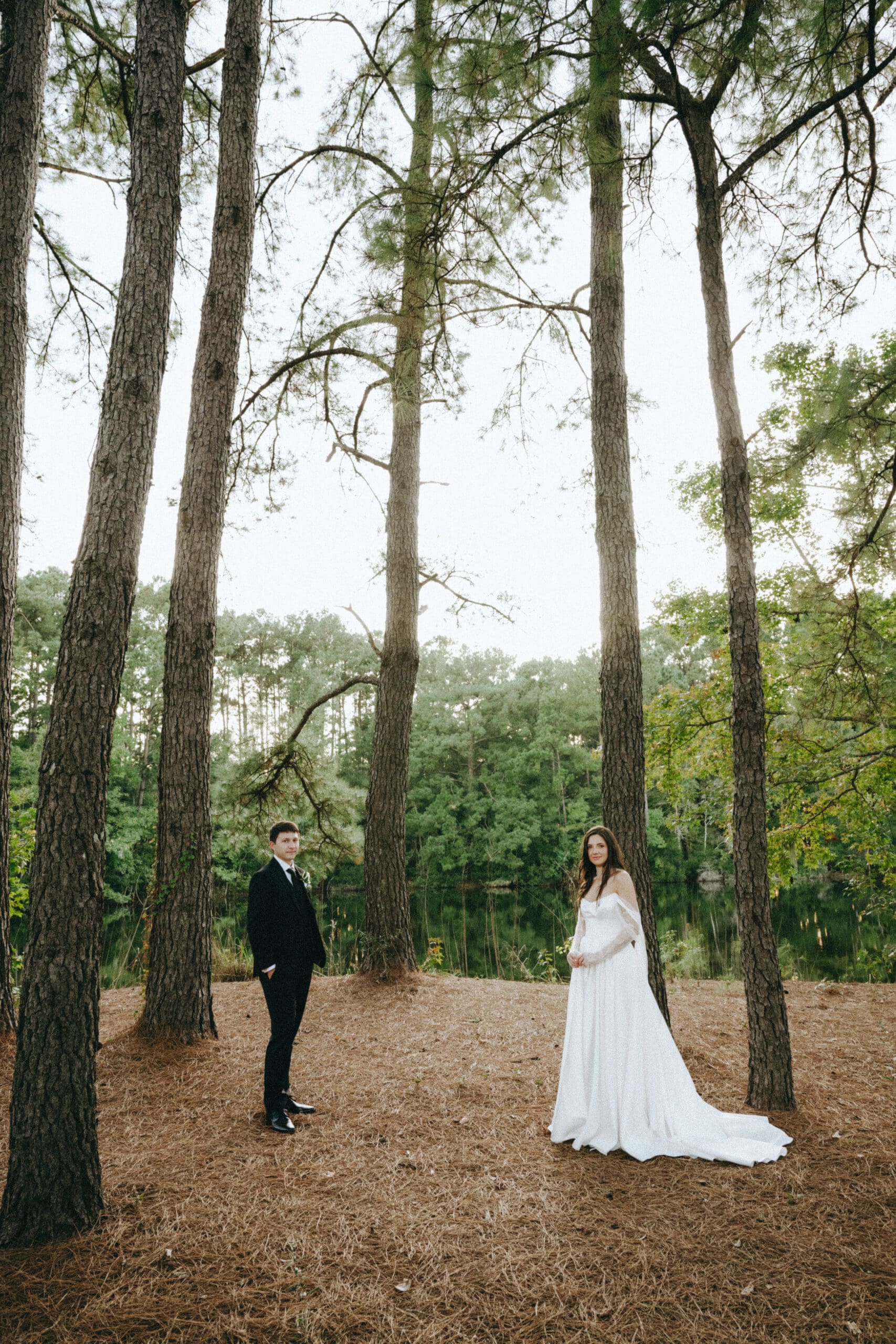 couples portrait outside in trees at lake house at bulow