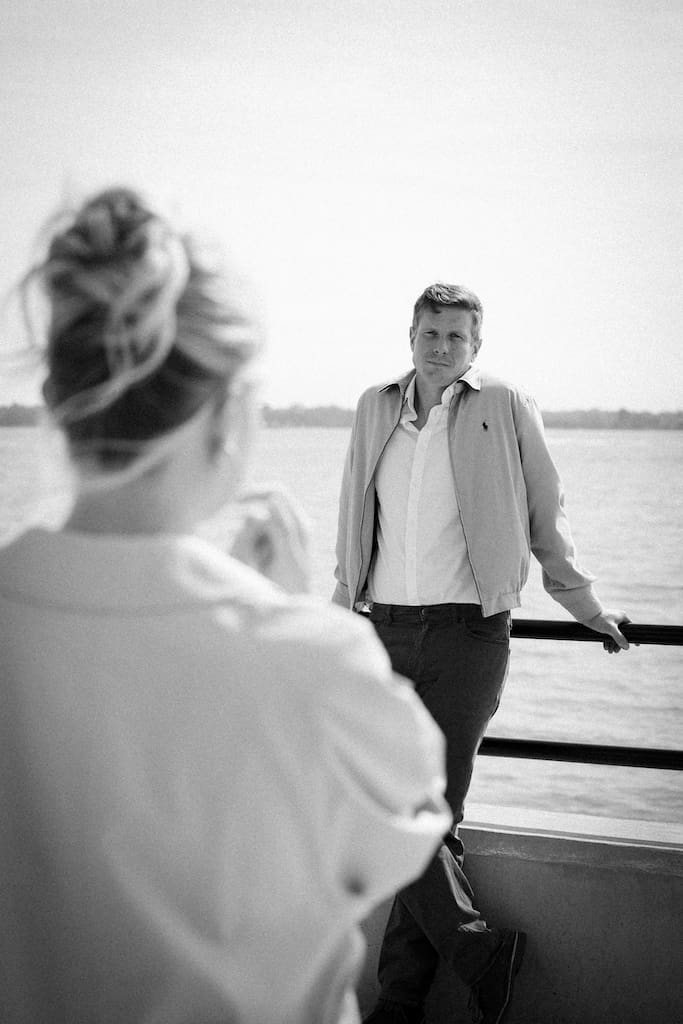 cinematic black and white photo of couple looking at each other over shoulder at battery park downtown charleston
