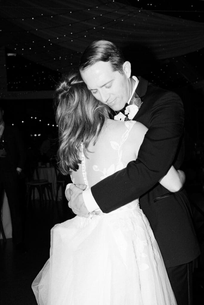black and white photo of couple on their wedding day dancing and laughing candidly at shepherds run inn in rhode island