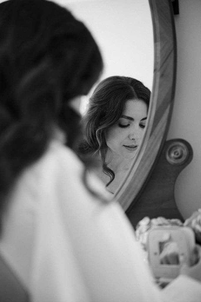 bride getting ready in mirror black and white