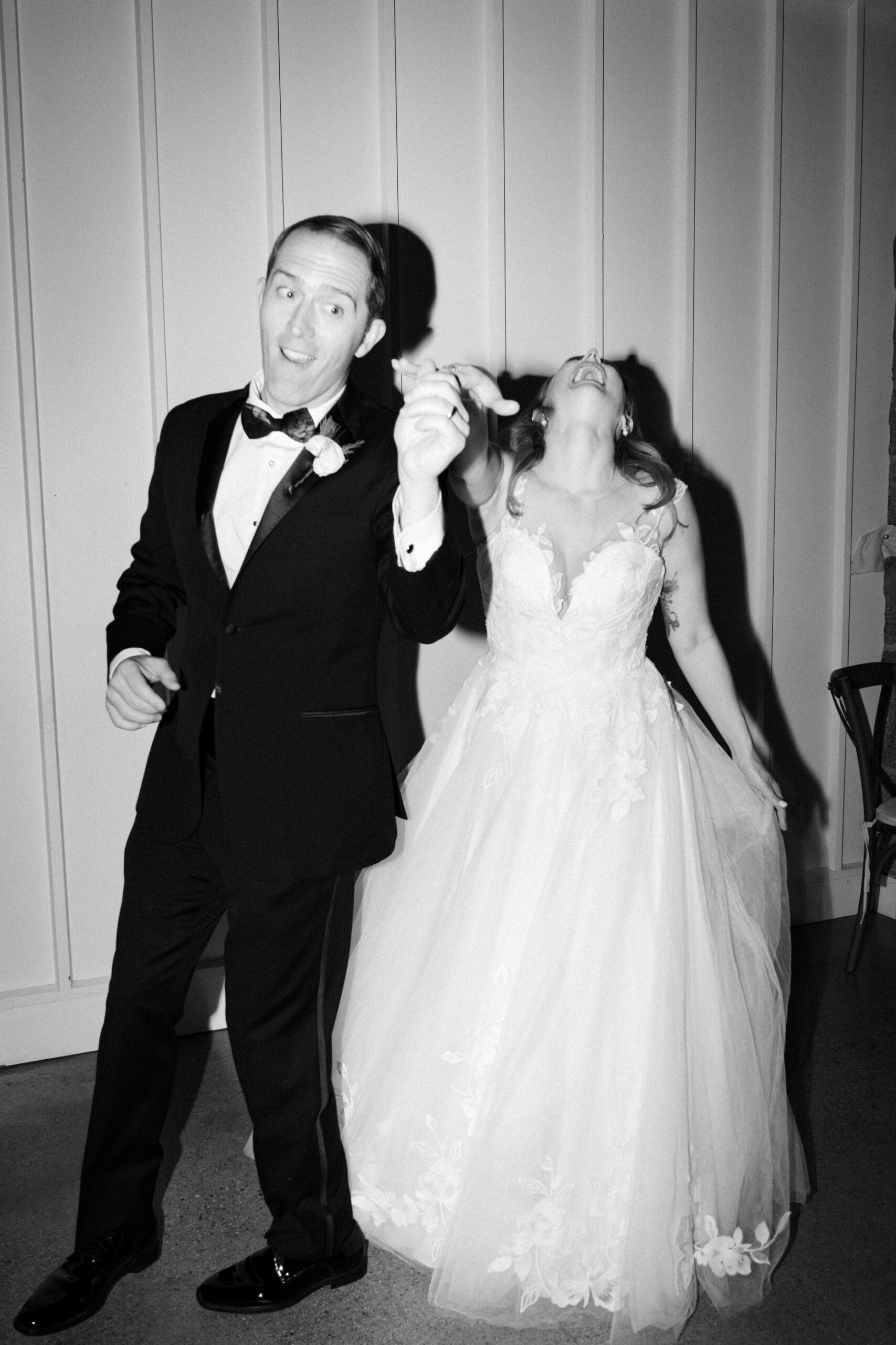 black and white photo of couple on their wedding day dancing and laughing candidly at shepherds run inn in rhode island