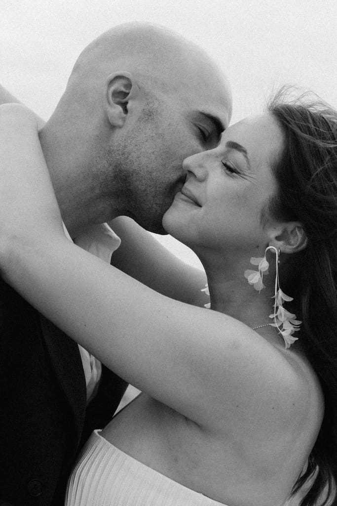 candid black and white portrait of couple on their wedding day on beach